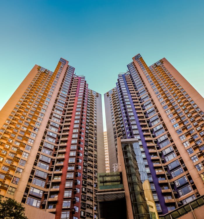 Home Tall, colorful skyscrapers reaching into the blue sky in Hong Kong, showcasing modern architecture.